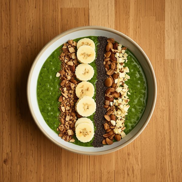 Grön smoothieskål med banan, frön och nötter